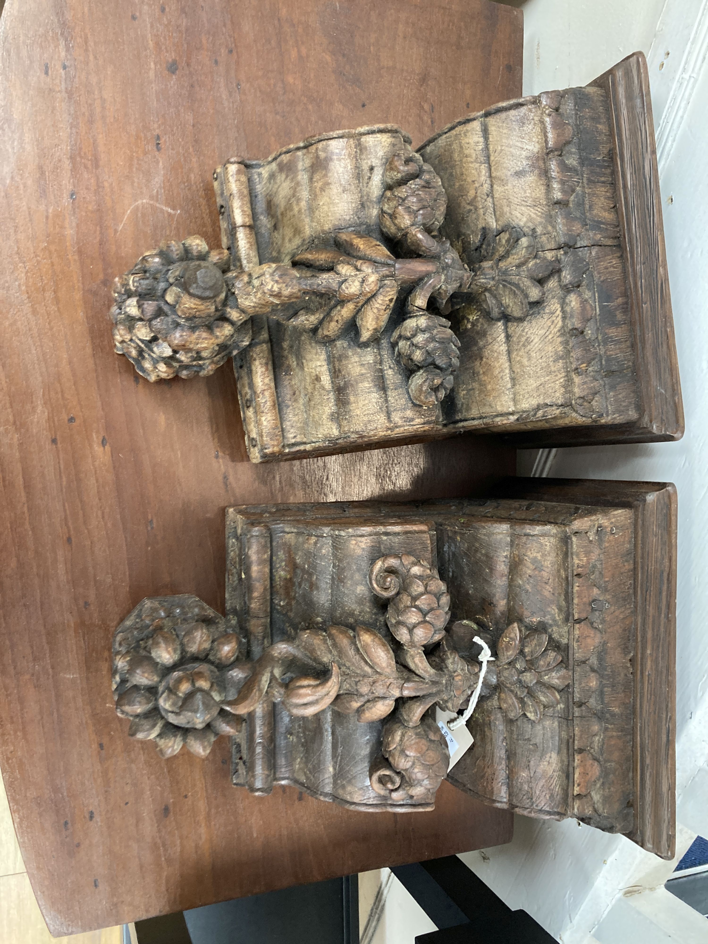 A pair of Indian teak wall brackets carved with lotus. W-25, H-34cm.